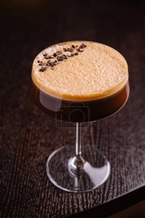 Nahaufnahme eines schaumigen Espresso Martini, garniert mit Kaffeebohnen, serviert in einem edlen Glas