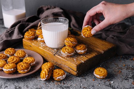 Delectable viennese whirls on a rustic wooden board with a glass of milk
