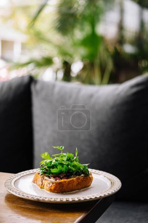 Delicious open-faced sandwich garnished with fresh herbs, served on an outdoor patio
