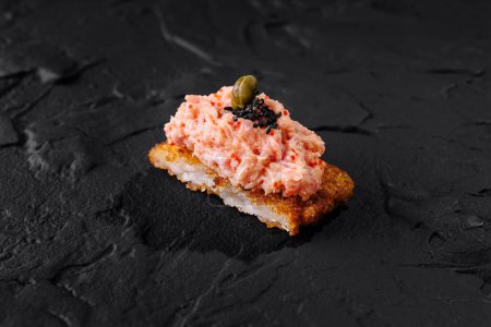 Elegant salmon tartare on a crispy rice base, garnished with capers, perfect for fine dining menus