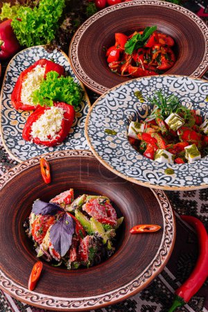 Verschiedene mediterrane Gerichte auf verzierten ethnischen Tellern, garniert mit frischen Kräutern