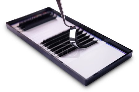 Close-up view of meticulous eyelash extension procedure using tweezers in a professional beauty salon