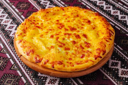 Mouthwatering cheese pizza served on a wooden board with a decorative tablecloth background