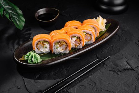 Delectable salmon sushi served on a sleek dark plate with soy sauce, perfect for asian cuisine themes