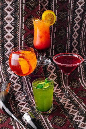 Téléchargez les photos : Une gamme vibrante de boissons mélangées sur un fond complexe à motifs, adapté pour une occasion festive - en image libre de droit