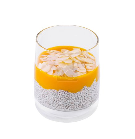 Glass of layered chia seed pudding with vibrant mango puree and almond toppings