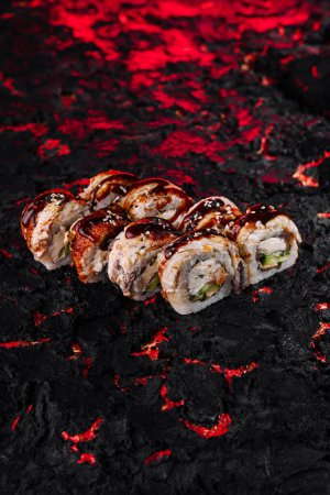 Presentación creativa del rollo de sushi en una superficie texturizada como de lava ardiente, mejorando el atractivo visual de la cocina japonesa