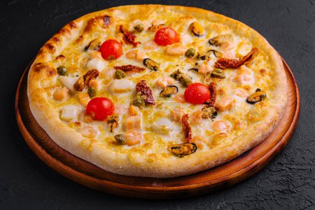 Délicieuse pizza aux fruits de mer avec crevettes, moules et tomates cerises sur une planche en bois rustique