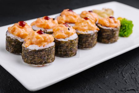 Świeże pikantne krewetki sushi rolki serwowane na nowoczesnym białym talerzu z ciemnym tle