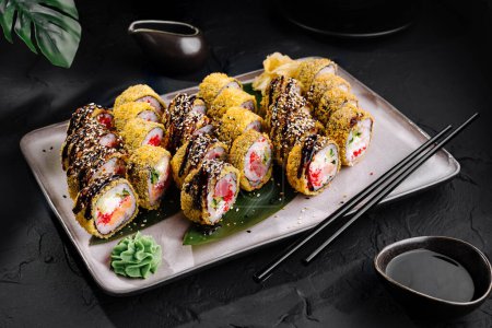 Wykwintne bułki sushi z żywymi nadzieniami i dodatkami, podawane na nowoczesnym talerzu z pałeczkami