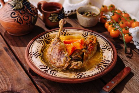 Succulent duck leg served with baked vegetables on a patterned ceramic plate