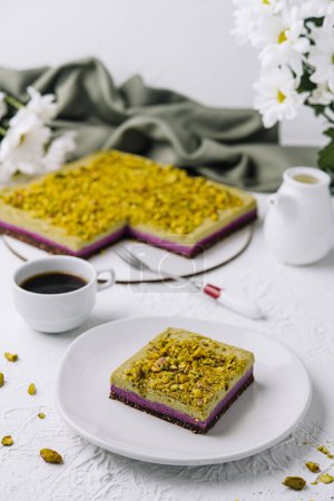 Tempting slice of pistachio cake paired with a fresh cup of coffee, elegant table setting
