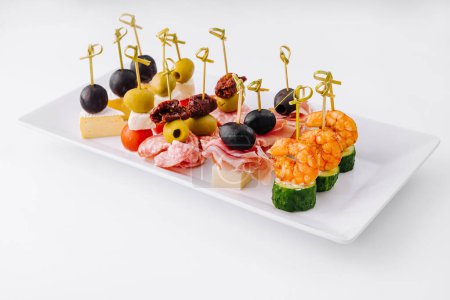 Photo for Exquisite gourmet finger food appetizer platter with an elegant assortment of cheese. Shrimp. Olives. Salami. Cucumber. Grape. And sundried tomato. Perfect for catering. Parties. And banquets - Royalty Free Image