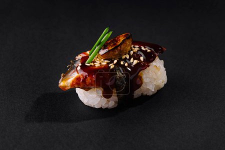 Exquisite eel sushi with savory sauce, garnished with sesame and green onion
