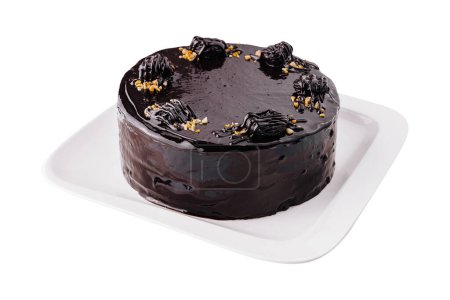 Gourmet dark chocolate cake with glossy ganache topping and decorative accents isolated on white