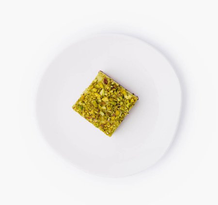 Top view of a delicious pistachio-flavored pastry on a clean white dish, isolated on a white background