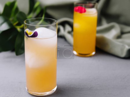 Téléchargez les photos : Verres élégants de cocktails ornés de fleurs comestibles, sur fond chic - en image libre de droit