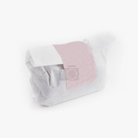 Isolated image of an item wrapped in paper with blank label on white, suitable for design mockups