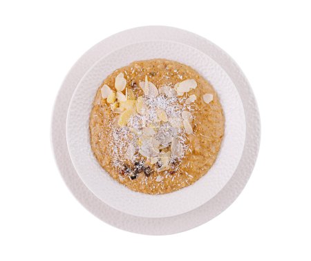 Top view of a healthy bowl of almond and coconut porridge, isolated on white background