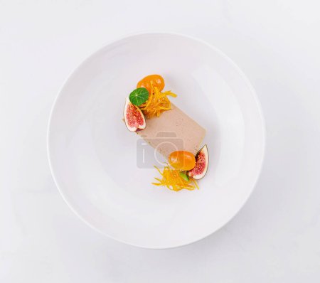 Modernes Dessert mit frischen Früchten und kunstvoller Dekoration, serviert auf einem glatten weißen Hintergrund