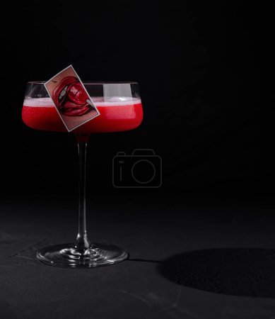 Raffinierter Cocktail mit leuchtend roter Schicht und dekorativer Dekoration schafft ein markantes Bild
