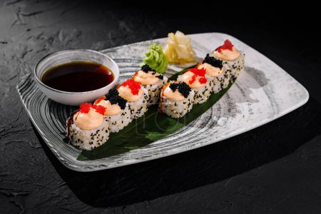 Eleganckie bułki sushi ozdobione kawiorem i dodatkami, podawane z sosem sojowym