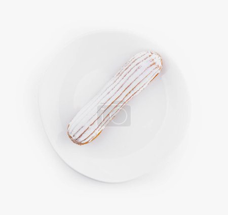 Top view of a delicious eclair with icing on a clean white plate