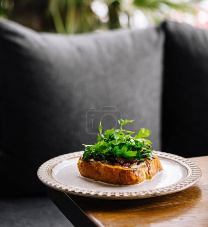 Delicious open-faced sandwich garnished with fresh herbs, served on an outdoor patio