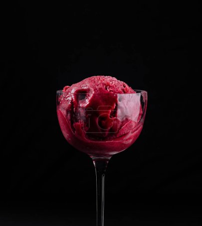 Close-up of a tempting strawberry sorbet served in a delicate glass against a dark backdrop