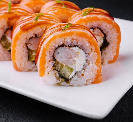 Zbliżenie świeżego sushi z łososia podanego z imbirem i wasabi na eleganckim białym talerzu