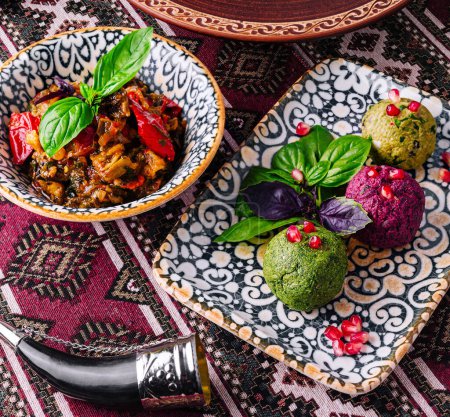 Exotische Gerichte mit lebendigen Beilagen, serviert in dekorativen Schalen auf einer gemusterten textilen Oberfläche