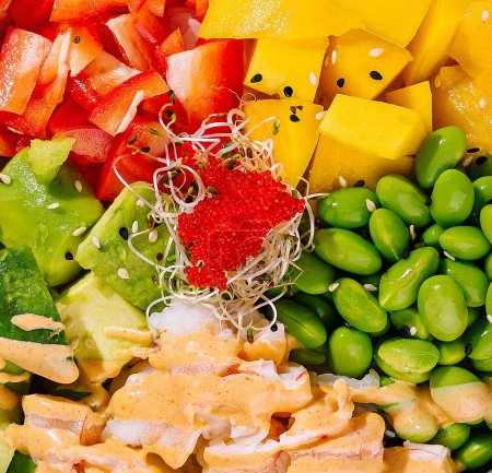 Colorful bowl of salad with shrimps, avocado, mango, and edamame close up