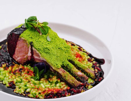 Exquisite roasted lamb rack with vibrant green herb crust and a rich berry reduction, served elegantly