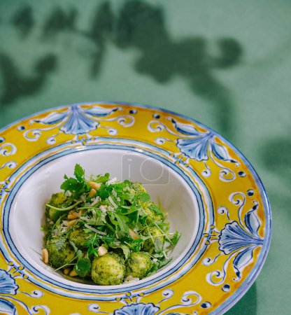 Élégante présentation de mozzarella pesto avec garnitures sur une assiette décorative, jetant une ombre