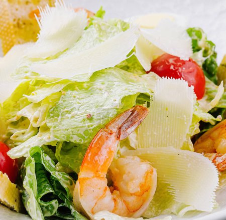 Téléchargez les photos : Salade césar appétissante aux crevettes succulentes, au parmesan rasé et aux croûtons dorés - en image libre de droit