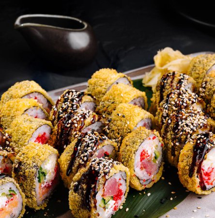 Wykwintne bułki sushi z żywymi nadzieniami i dodatkami, podawane na nowoczesnym talerzu z pałeczkami
