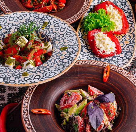 Verschiedene mediterrane Gerichte auf verzierten ethnischen Tellern, garniert mit frischen Kräutern