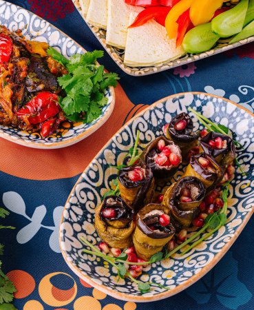 Lebendige Gerichte einer mediterranen Mahlzeit auf einer dekorativen Tischdecke ausgebreitet