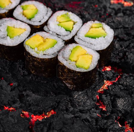 Exquisite avocado sushi rolls artfully presented on a vibrant lava-like textured background