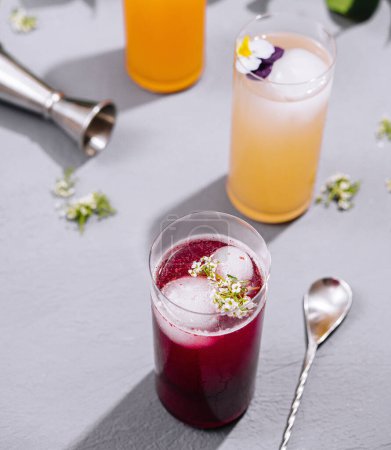 Foto de Elegantes bebidas de verano adornadas con flores comestibles, perfectas para una reunión sofisticada - Imagen libre de derechos