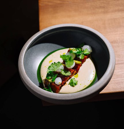 High-end cuisine in a black bowl, artistically plated with a modern touch
