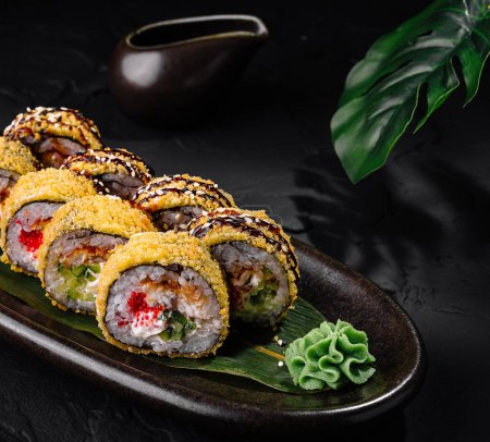 Rollos de sushi frescos adornados con semillas de sésamo en un plato de cerámica elegante, con palillos y salsa de soja
