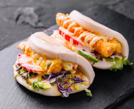 Tasty chicken bao buns served on a slate plate, perfect for modern asian cuisine menus