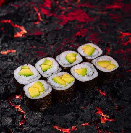 Exquisite Avocado-Sushi-Rollen kunstvoll präsentiert auf einem lebendigen Lava-ähnlichen strukturierten Hintergrund