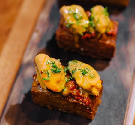 Elegant small bites served on a rustic wooden plank, perfect for fine dining menus