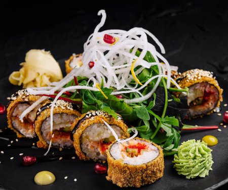 Téléchargez les photos : Présentation élégante de rouleaux de sushi avec garnitures sur fond d'ardoise sombre - en image libre de droit