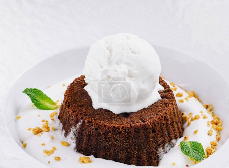 Gourmet chocolate lava cake topped with a scoop of vanilla ice cream, garnished with mint leaves