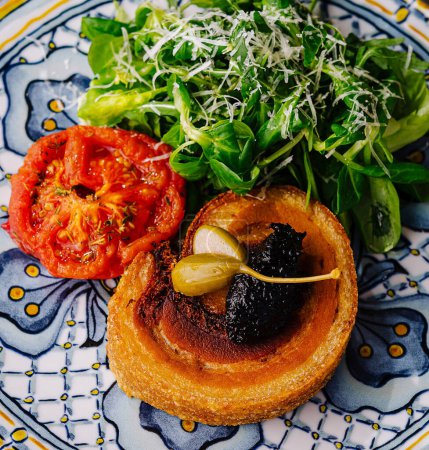 Vista elevada de un delicioso brindis con tomate, verduras y untado en un plato de diseño
