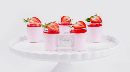 Anspruchsvoller weißer Stand zeigt Erdbeer-Panna-Cotta garniert mit frischen Beeren