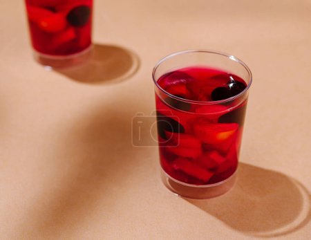 Trois verres de queues de baies rouges sur un fond beige chaud avec des ombres ludiques